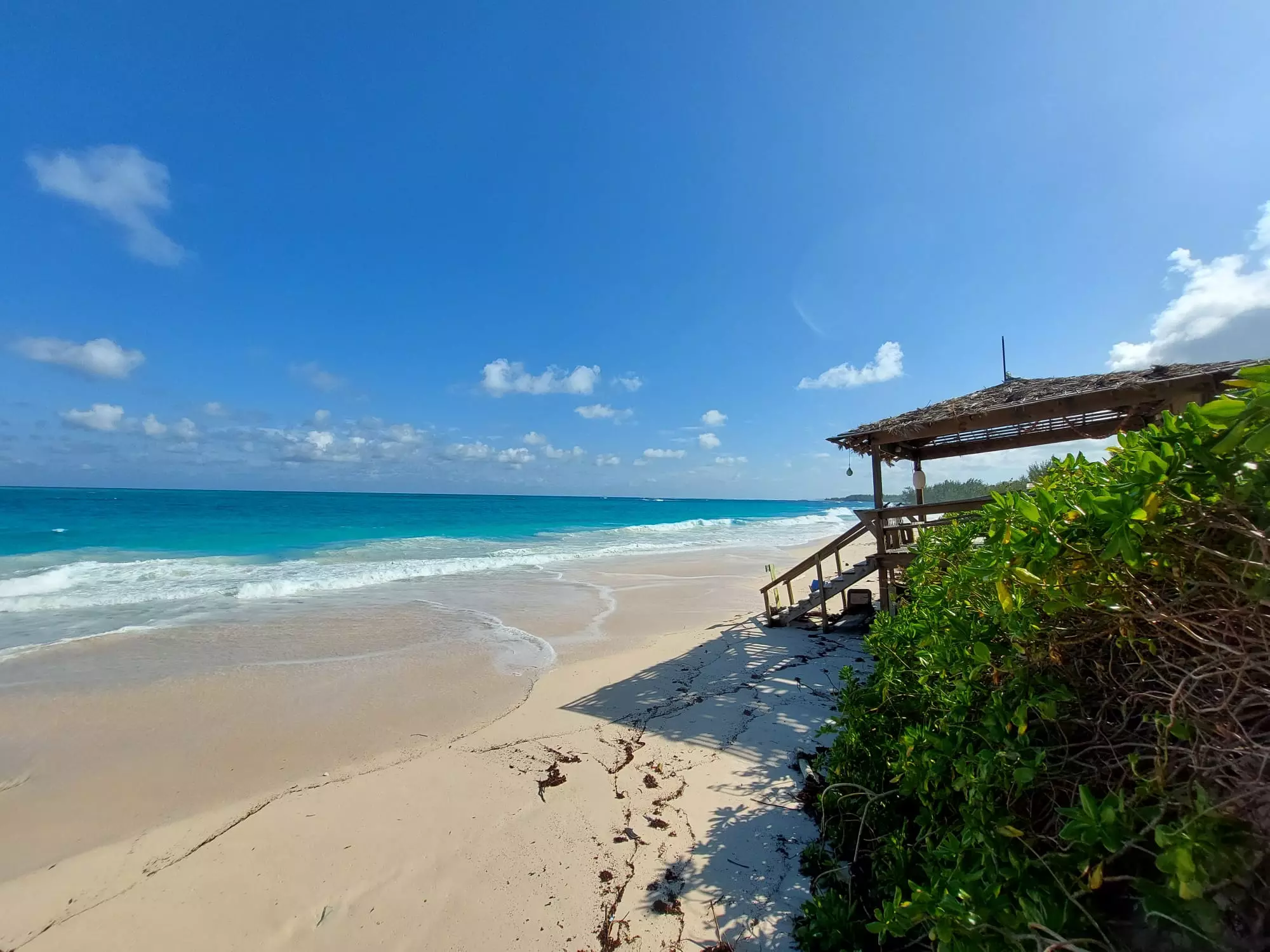 Spiaggia bianca con gazebo di legno e mare turchese alle Bahamas
