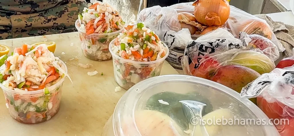 Conch salad appena preparate in vaschette su un bancone, con lime, cipolla, pomodoro e peperoni, in un chiosco delle Bahamas