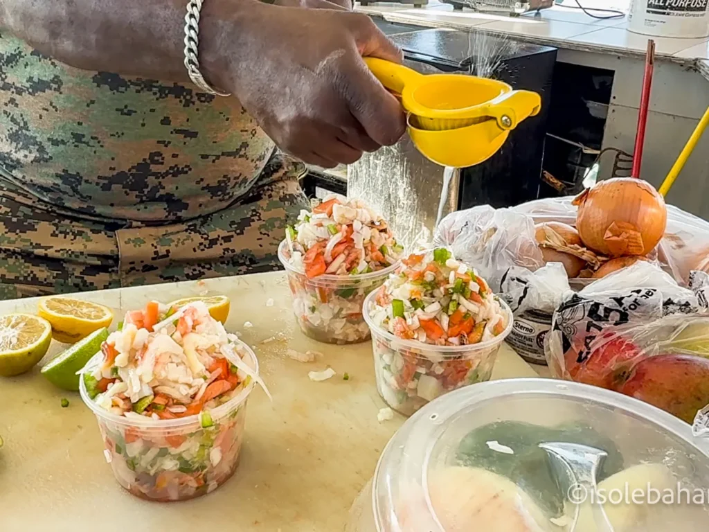 Preparazione della conch salad con lime spremuto al momento in un chiosco delle Bahamas
