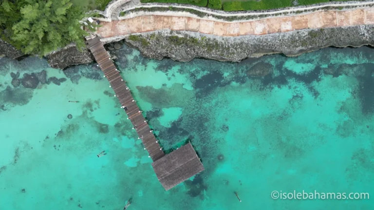 Lungo pontile in legno sull'acqua turchese a Governor's Harbour, Eleuthera, visto dal drone
