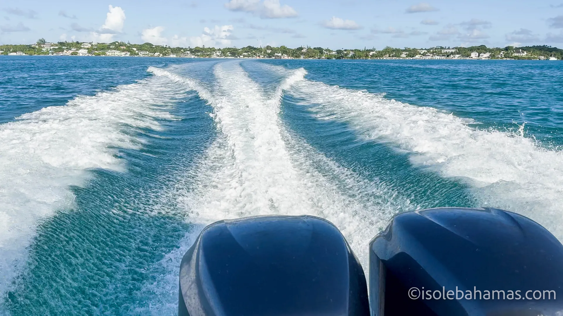 Scia di un motoscafo che si allontana dalla costa tra le isole Bahamas